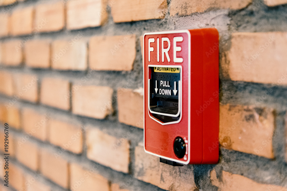 Close up fire alarm activation box on brick wall in room Close up fire alarm activation box on brick wall in room