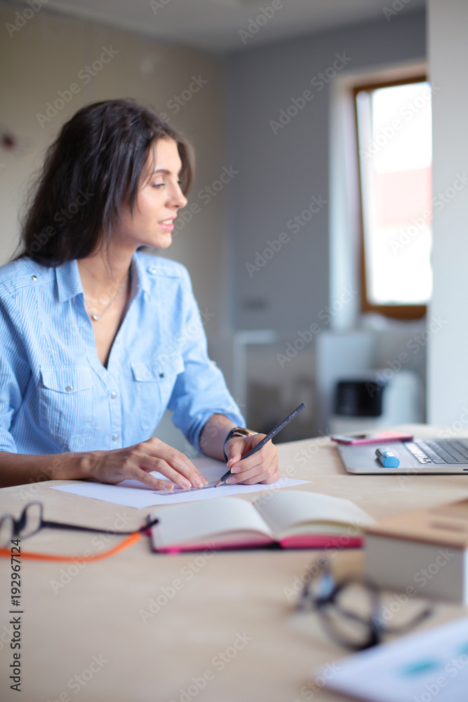 Young woman sitting at office table with laptop. Young woman. Laptop Young woman sitting at office table with laptop. Young woman. Laptop