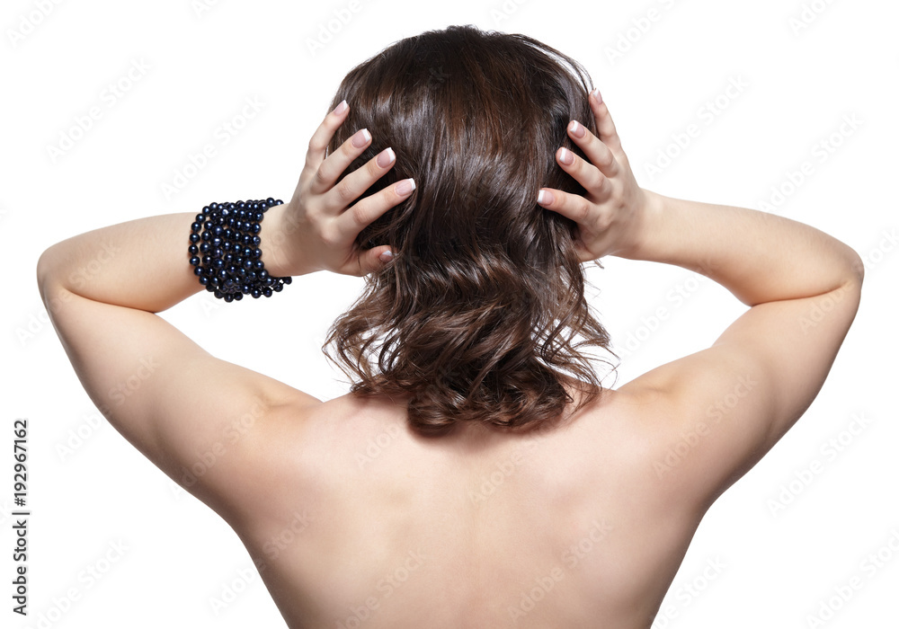 Brunette woman from backside on gray background Brunette woman from backside on gray background