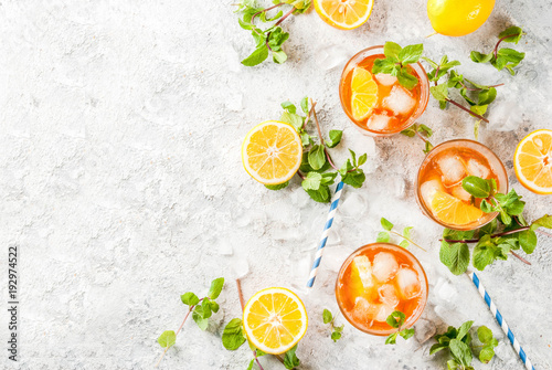 Cold summer drink. iced tea with lemon and mint  on grey stone background.  Copy space  top view