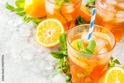 Cold summer drink. iced tea with lemon and mint  on grey stone background.  Copy space