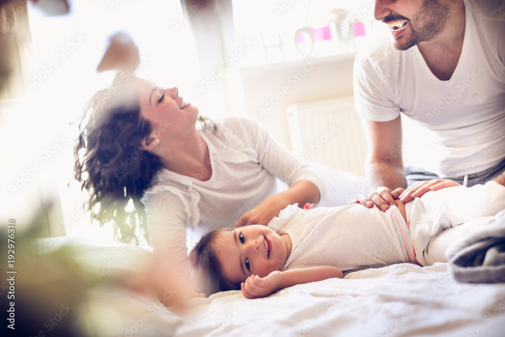 Obraz premium Little girl with her parents playing at morning.