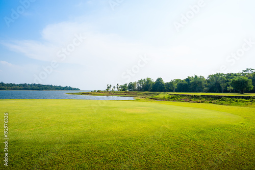 green grass field with lake in public park