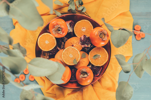 Fototapeta Naklejka Na Ścianę i Meble -  top view of leaves falling on fruits on plate