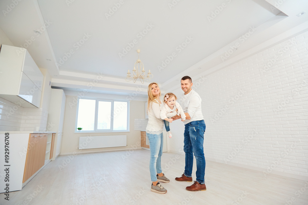 A happy family plays with a child together in a bright house team. Mother father and child. A happy family plays with a child together in a bright house team. Mother father and child.