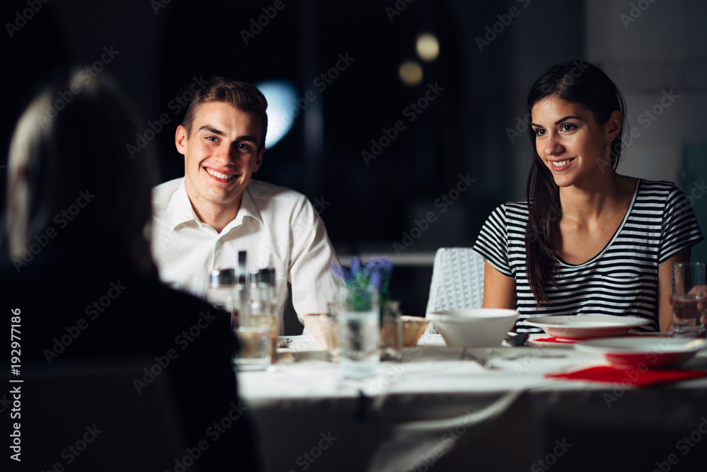 Group of friends having a dinner in a restaurant.Double date.Attractive people night out,dining in a hotel.Trendy people visiting a new opened place.Best friends gathering.Travel accommodation food