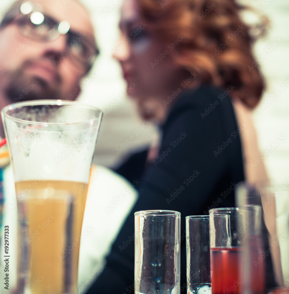 party time talking couple at alcohol glasses background