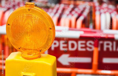Yellow warning light and red street barriers