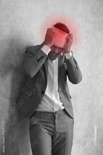 Overworked young man having headache once onerous operating day.sick man headache, dizzyness, sinus inflammation, stress, migraine.black and white body pain concept
