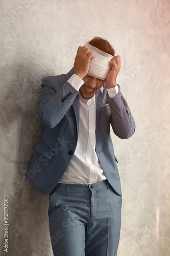 Overworked young man having headache once onerous operating day.sick man headache, dizzyness, sinus inflammation, stress, migraine.