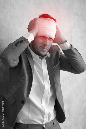 Overworked young man having headache once onerous operating day.sick man headache, dizzyness, sinus inflammation, stress, migraine.black and white body pain concept
