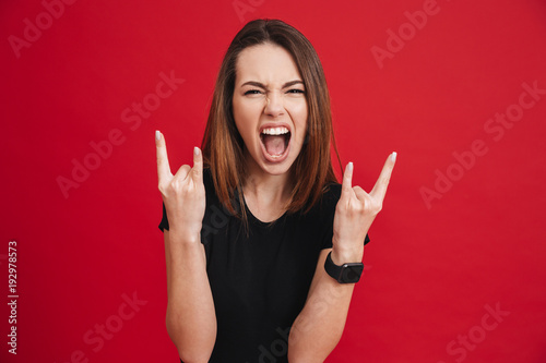 Valokuvatapetti Portrait of a screaming girl showing horns up gesture