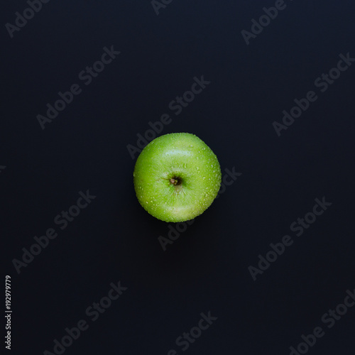 Green apple on black background