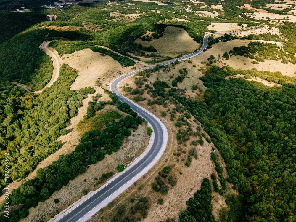 Aerial above view of a rural landscape with a curvy road running through it in Greece. Aerial above view of a rural landscape with a curvy road running through it in Greece.