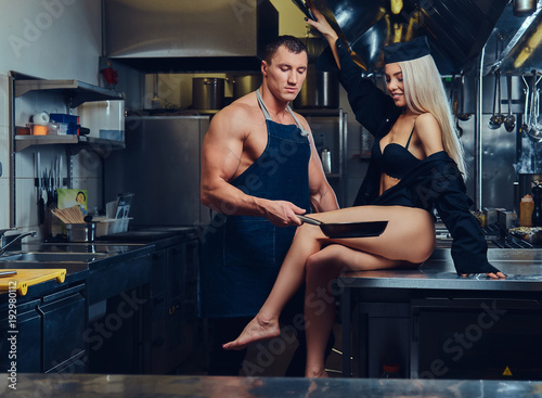 A sexy waitress flirts with an attractive cook. photo