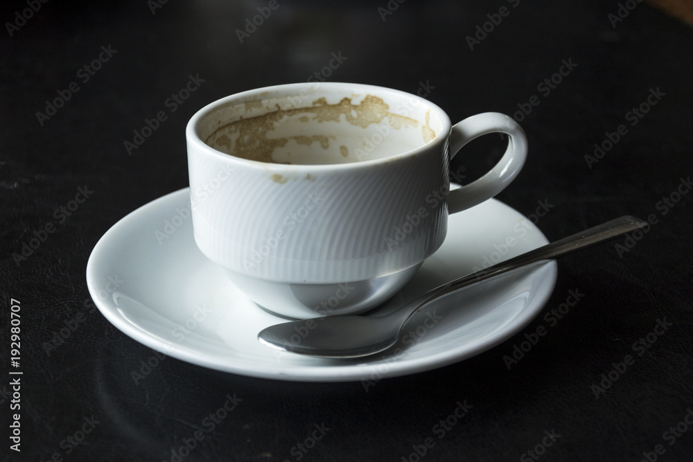 Empty white cup and saucer with tea spoon Empty white cup and saucer with tea spoon