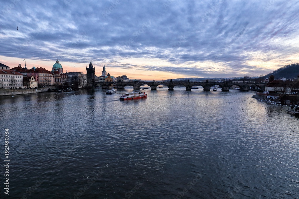 Charles bridge and river Vltava with some boats in the evening