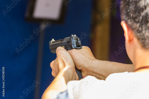 Blurred Image - Man practicing shooting in the amusement park. selective focus the gun