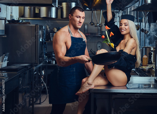 A sexy waitress flirts with an attractive cook. photo