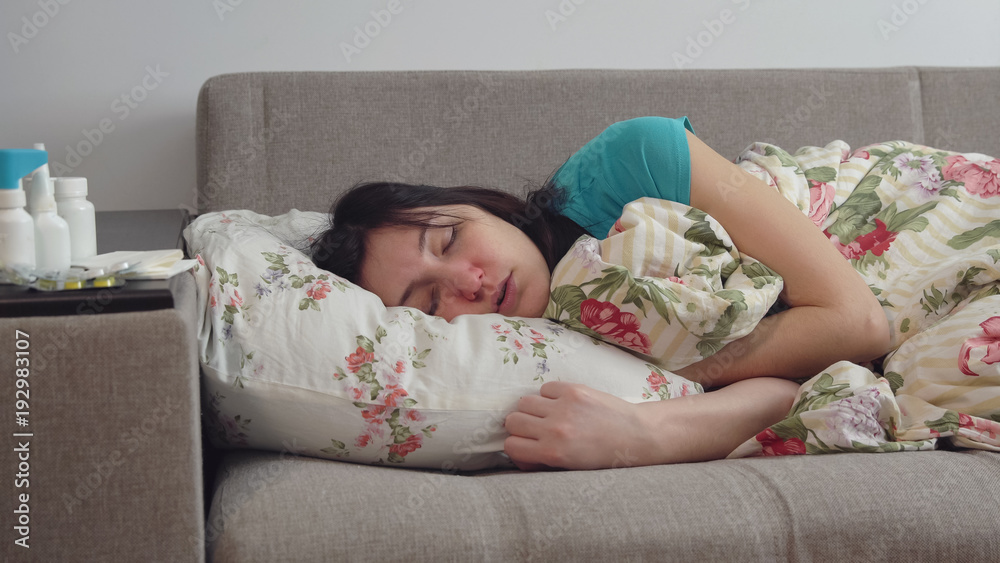 Young woman lying on bed with common cold