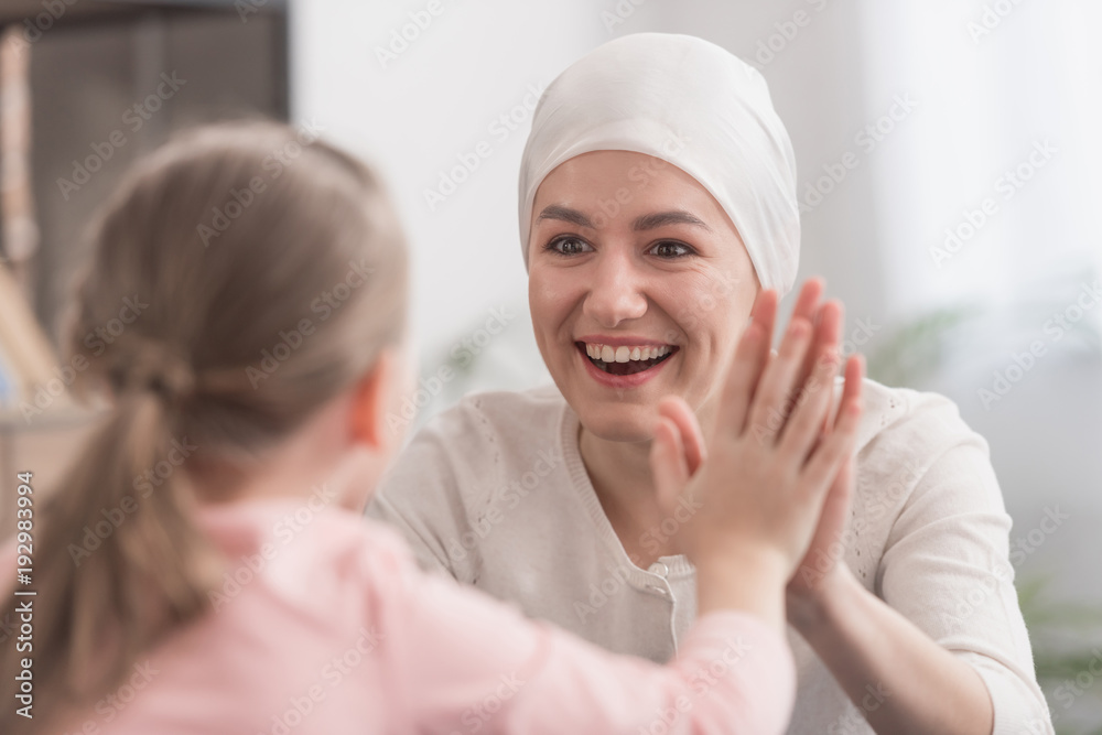 child and sick mother in kerchief holding hands and smiling each other child and sick mother in kerchief holding hands and smiling each other