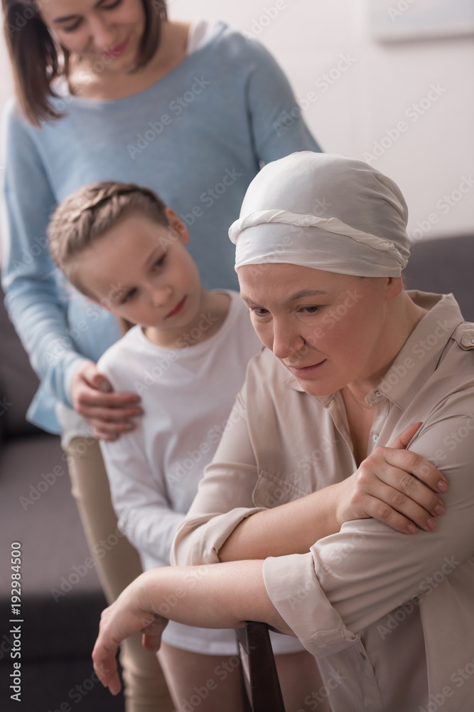 family supporting mature sick woman in kerchief family supporting mature sick woman in kerchief