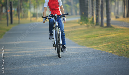 woman cyclist riding bike in tropical park © lzf