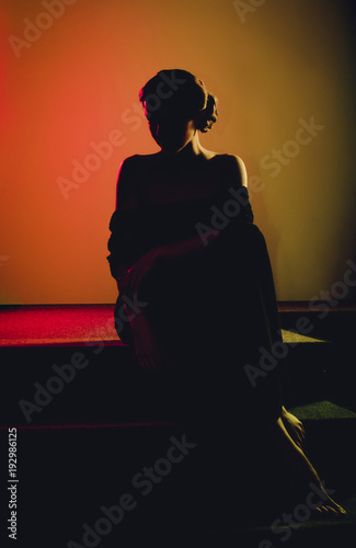 Obraz na płótnie Dark black silhouette of elegant woman done in colorful lighting by photo filter gels. w salonie