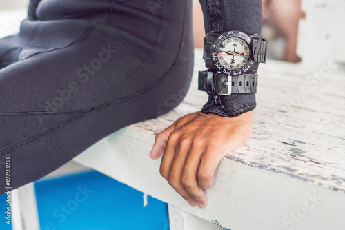 Young diver preparing an underwater compass for diving photo