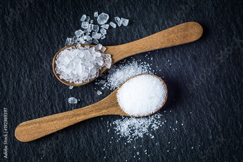 Different types of salt. Top view on two wooden spoons