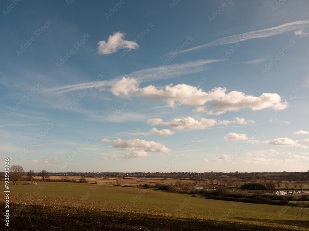 Naklejka premium large open grass plain field with blue cloudy sky background nature