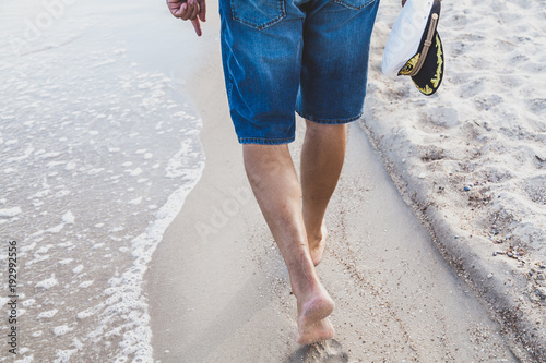 Man walks on the sea beach © glebchik