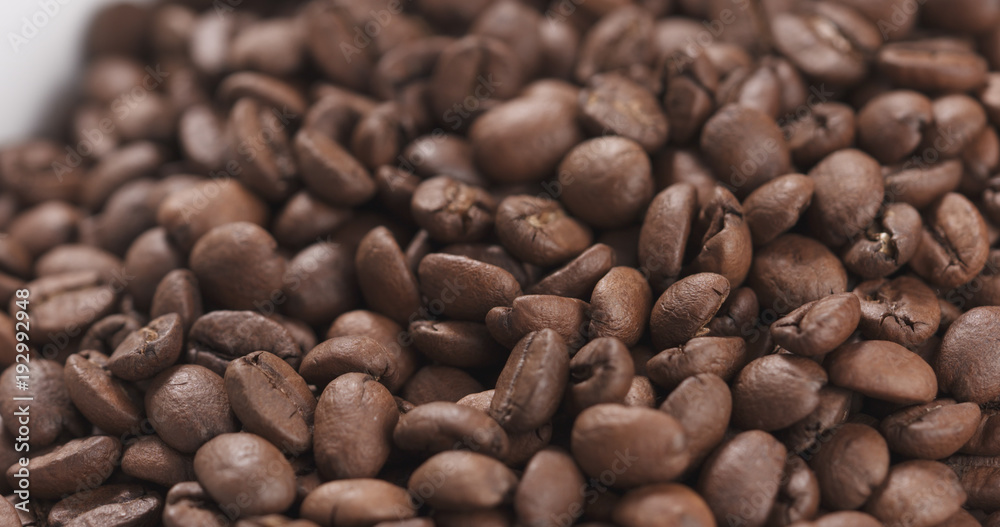 closeup coffee beans falling into bowl closeup coffee beans falling into bowl
