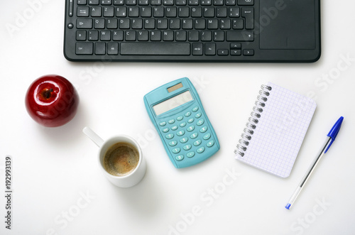 Computer keyboard, notebook, coffee on office desk,