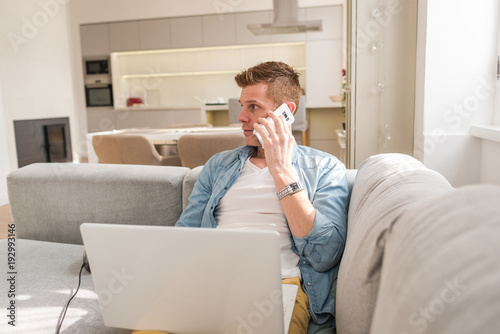 young Man sitting in sofa and using laptop