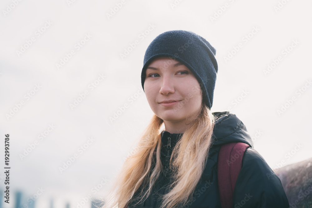 urban portrait of teen girl walking in the city in autumn or spring