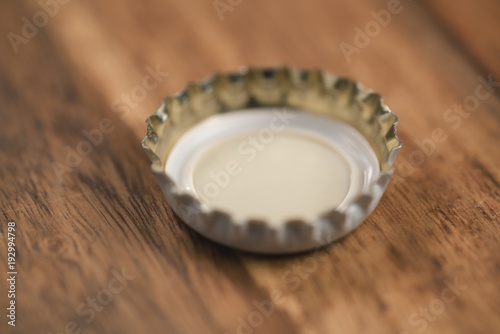 single white beer bottle cap on wood table