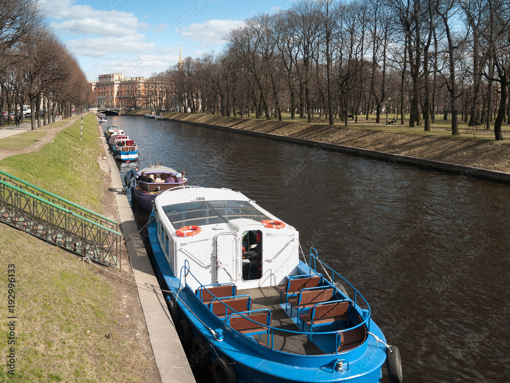 Naklejka premium Boats near the shore on the Moika River in St. Petersburg in April on a warm day