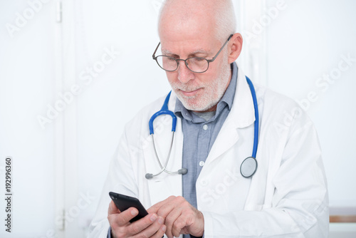 mature doctor on phone in his office