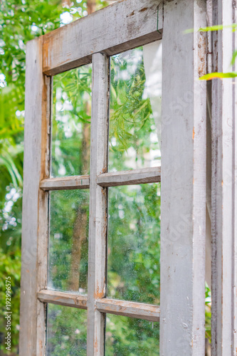 Opened vintage wooden door to green garden