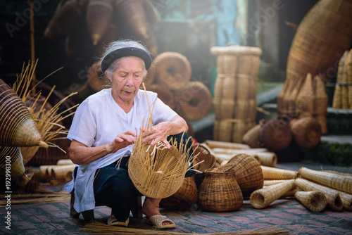 Vietnamese fishermen are doing basketry for fishing equipment at morning in Thu Sy Village, Vietnam. photo