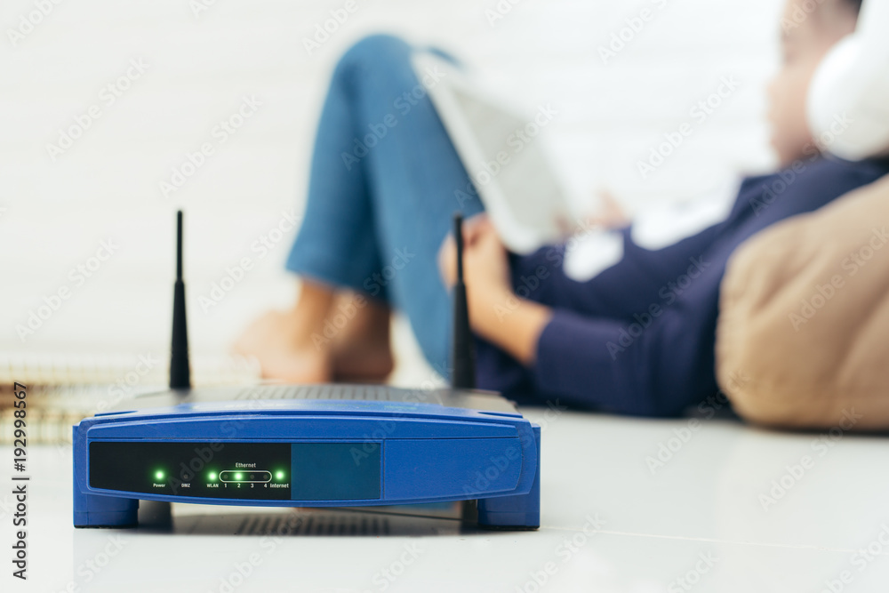 Wireless router and kids using a Tablet in home. router wireless broadband  home laptop computer phone wifi concept foto de Stock | Adobe Stock