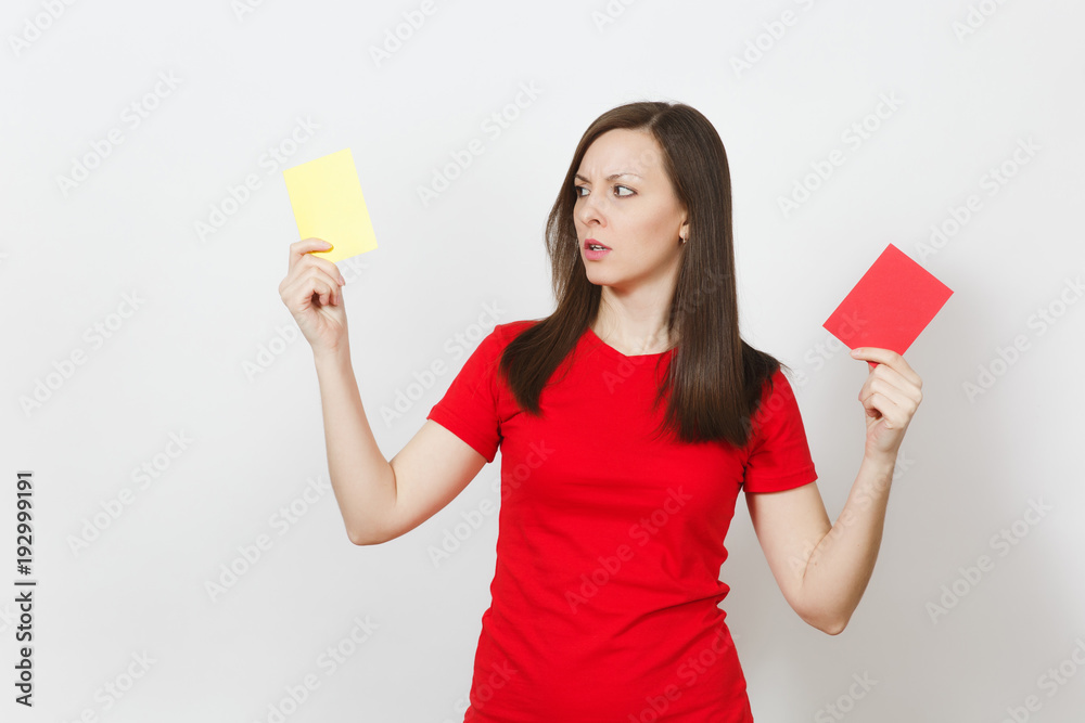 European serious severe young woman, football referee hold choose yellow and red soccer cards, propose player retire from field isolated on white background. Sport, play, healthy lifestyle concept. European serious severe young woman, football referee hold choose yellow and red soccer cards, propose player retire from field isolated on white background. Sport, play, healthy lifestyle concept.