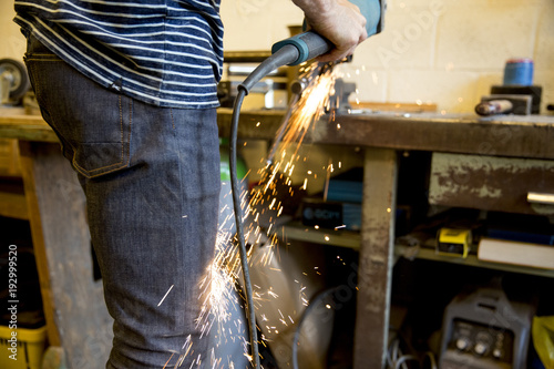 Carpenter grinding metal with sharpening tool © Bart