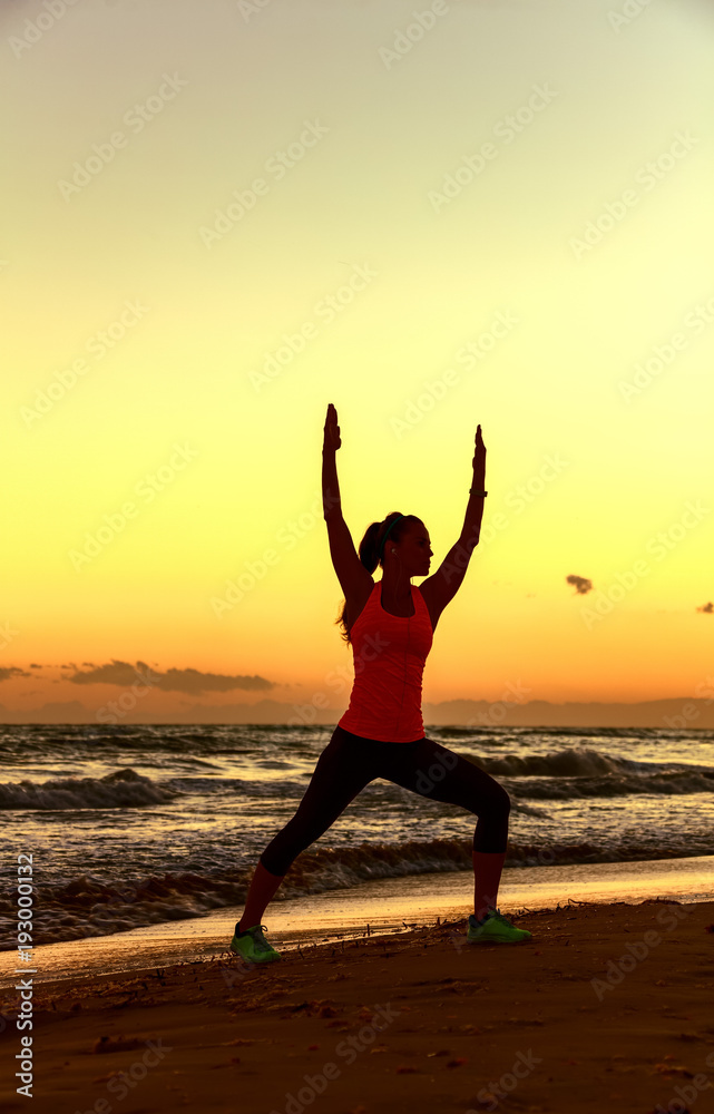 Silhouette of healthy woman in sportswear on seacoast workout