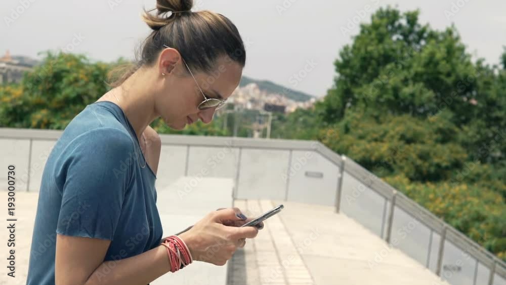 Young, elegant woman texting on smartphone sitting on bench in city
Young, elegant woman texting on smartphone sitting on bench in city