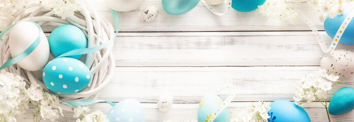 Easter Decoration with Eggs and Flowers on White Wooden Background
