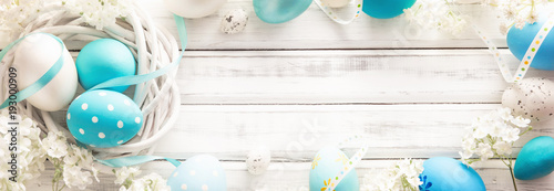 Easter Decoration with Eggs and Flowers on White Wooden Background