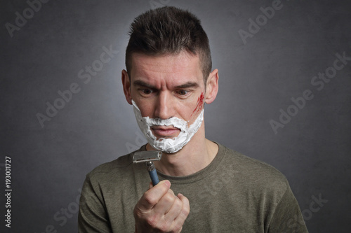 homme se coupant en se rasant avec rasoir à lames vintage photo