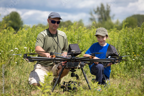 learning to fly a drone, father trains son piloting drone